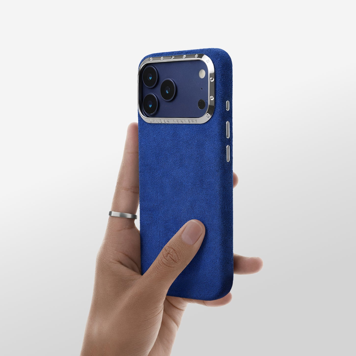 Hand holding Blue Alcantara iPhone 17 case with high-polished aluminum camera frame