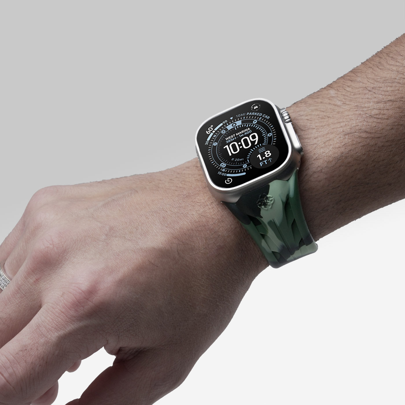 Apple Watch worn with green camouflage rubber strap, lifestyle wrist view