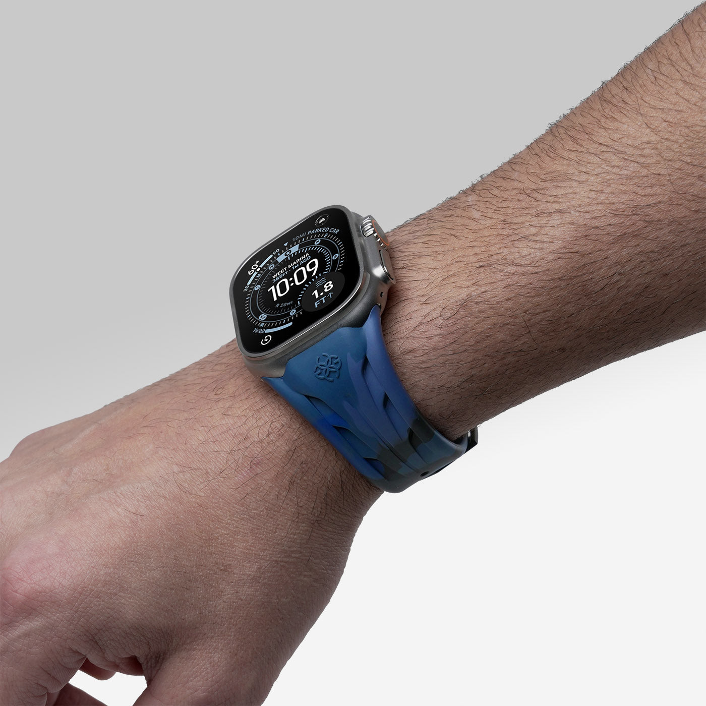 Apple Watch worn with blue camouflage rubber strap, lifestyle wrist view